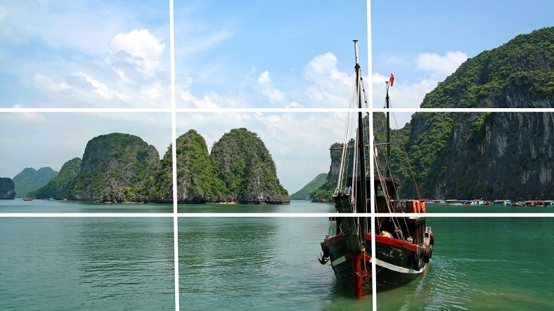 Áp dụng quy tắc 1/3 trong nhiếp ảnh và quay phim với hình ảnh con thuyền nằm ở giao điểm bên phải khung hình trên Vịnh Hạ Long.